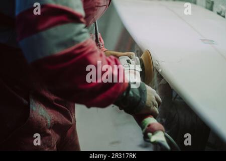 Un surf shaper locale di Tenerife che lavora su una nuova tavola da surf Foto Stock