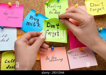 Donna pinning carta nota con frase non dimenticare di sughero bordo, primo piano Foto Stock