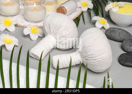 Borse benessere, pietre e fiori d'orchidea su tavolo grigio chiaro Foto Stock