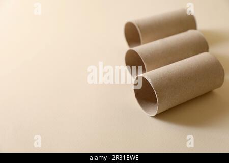 Rotoli di carta igienica vuoti su sfondo beige. Spazio per il testo Foto Stock