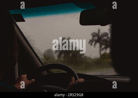 persona che guida durante la tempesta Foto Stock