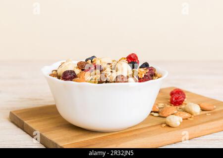 Cucinare una sana colazione. Granola con vari frutti secchi e noci in una ciotola. Il concetto di un dessert sano. Piano di giacitura, vista dall'alto con sp. Copia Foto Stock
