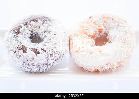 Ciambelle al cioccolato e alla vaniglia su piatto bianco Foto Stock