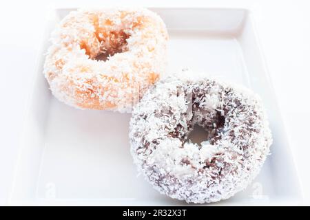 Ciambelle al cioccolato e alla vaniglia con copertura al cocco Foto Stock