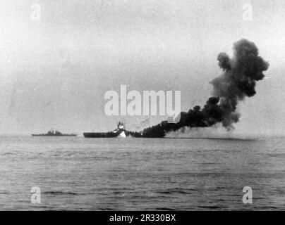 Un secondo kamikaze giapponese, un Mitsubishi A6M Zero pilotato da Ensign Kiyoshi Ogawa, colpisce gli Stati Uniti Portaerei Navy USS Bunker Hill (CV-17) a bordo delle navi, circa 1005 ore, 11 maggio 1945. La nave sta già bruciando da un colpo di kamikaze 30 secondi prima. Lo sciopero ha catturato aerei completamente alimentati e armati sul ponte e ha iniziato incendi molto pericolosi. Anche se gravemente danneggiata, la nave non affondò e tornò negli Stati Uniti per la riparazione. La nave è stata smantellata nel 1966 e demolita nel 1973. Foto Stock