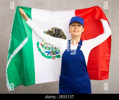 Allegra lavoratrice con largo grin sul suo volto tenendo bandiera del messico Foto Stock