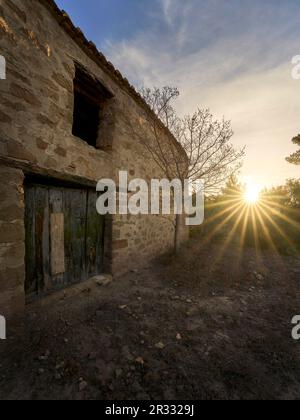 Casa rurale abbandonata con il sole all'alba Foto Stock