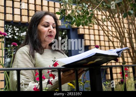 Londra, Regno Unito. 22 maggio 2023. Il pluripremiato poeta Imtiaz Dharker legge una poesia da una delle edizioni della Folio Society al Reading Room Garden della Folio Society durante il giorno della stampa della RHS Chelsea Flower Show nei terreni del Royal Hospital Chelsea. Lo spettacolo si svolge fino al 27 maggio 2023. Credit: Stephen Chung / Alamy Live News Foto Stock