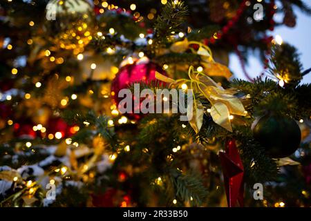 Bellissimi giocattoli multicolore su un albero di Natale sullo sfondo di luci e neve Foto Stock