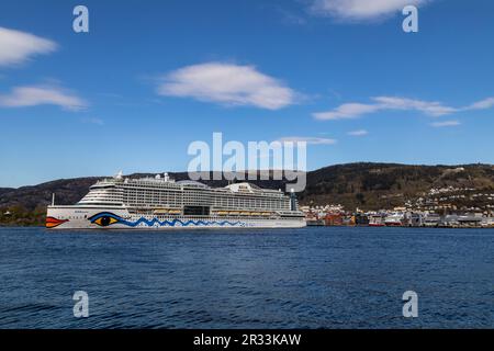 Nave da crociera AIDAperla con partenza dal terminal di Jekteviken nel porto di Bergen, Norvegia. Monte Floeyen in background Foto Stock