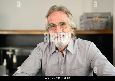 Uomo anziano felice con gli occhiali che guardano il ritratto della macchina fotografica Foto Stock