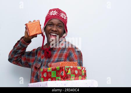 giovane africano eccitato che tiene i regali avvolti, felice Foto Stock