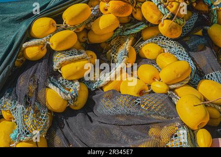 Reti da pesca con galleggianti gialli sul molo, primo piano, fuoco selettivo. Contesto del concetto di pesca industriale Foto Stock