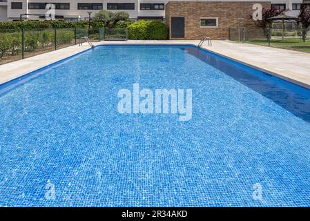 Una piscina in uno sviluppo urbano di alloggi con il tipo di gres blu rivestimenti in piastrelle Foto Stock