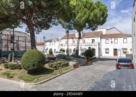 Piazza del paese con il municipio imbiancato e giardino con siepi nel centro Foto Stock