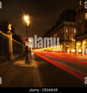 Vista sulla strada di Parigi di notte con tracce di luce dal traffico Foto Stock