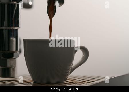 estrazione dell'espresso con portafiltro a beccuccio singolo dal primo piano della macchina da caffè, messa a fuoco poco profonda Foto Stock