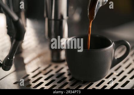 estrazione dell'espresso con portafiltro a beccuccio singolo dal primo piano della macchina da caffè, messa a fuoco poco profonda Foto Stock