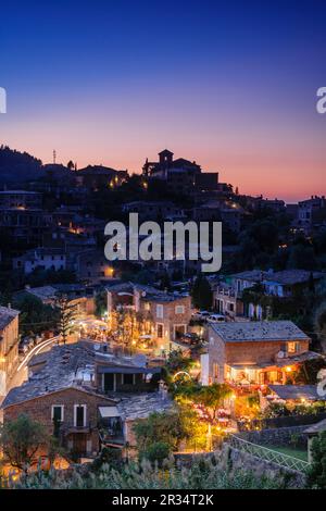 Restaurantes y la iglesia parroquial de San Juan Bautista , situada en la parte alta de la Villa de Deià. Sierra de Tramuntana. Mallorca. Islas Baleares. España. Foto Stock