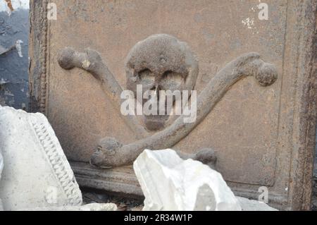 Memento mori, raffigurante un cranio e le ossa su una lapide in ghisa. Foto Stock