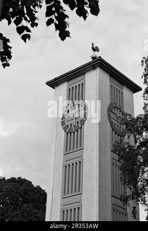 Una struttura torreggiante in cima ad una chiesa, spesso adornata con dettagli architettonici e una campana, che serve come un punto di riferimento prominente in una comunità. Foto Stock