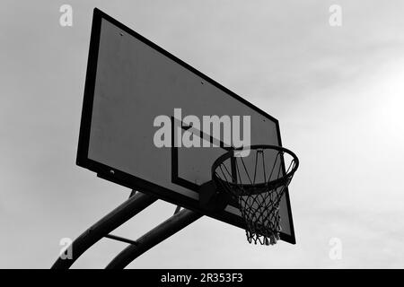 Un canestro da basket, montato su un backboard, fornisce un obiettivo per i giocatori per sparare la palla, aggiungendo eccitazione e sfida al gioco. Foto Stock