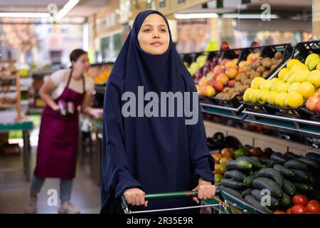 Ritratto di giovane donna acquirente in hijab in supermercato Foto Stock