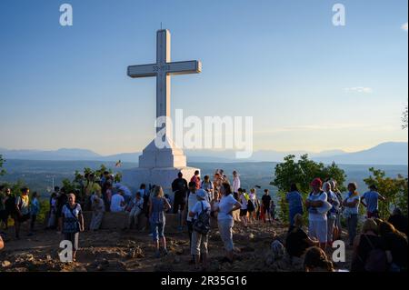 Pellegrini di prima mattina intorno alla croce bianca sulla cima del Monte Križevac (la montagna della Croce) a Medjugorje. Foto Stock