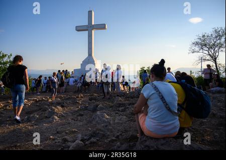 Pellegrini di prima mattina intorno alla croce bianca sulla cima del Monte Križevac (la montagna della Croce) a Medjugorje. Foto Stock