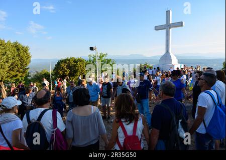 Pellegrini di prima mattina intorno alla croce bianca sulla cima del Monte Križevac (la montagna della Croce) a Medjugorje. Foto Stock