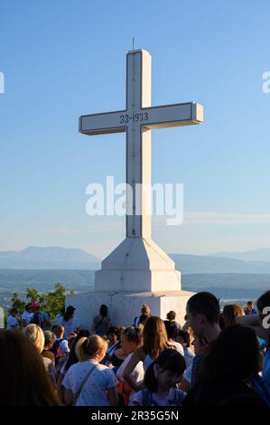 Pellegrini di prima mattina intorno alla croce bianca sulla cima del Monte Križevac (la montagna della Croce) a Medjugorje. Foto Stock