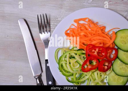 Spaghetti di verdure zucchine lowcarb su un piatto Foto Stock