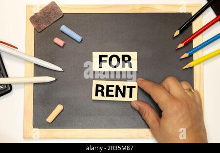 Immagine ravvicinata di modello di piccola casa su blocchi di legno con testo di garanzia affitto sopra la tabella. vista dall'alto. spazio di copia vuoto. Foto Stock