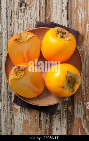 Persimions interi e tagliate a metà Foto Stock