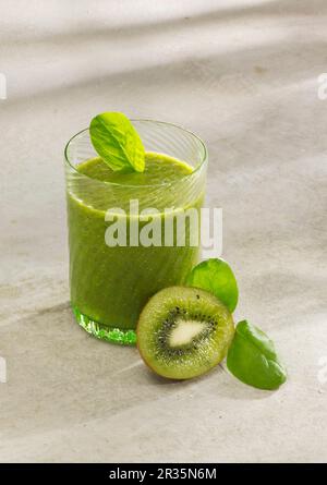 Frullato di spinaci e kiwi con latte di mandorle, semi di chia e erba di grano in polvere Foto Stock