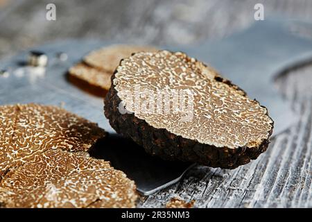 Tartufi estivi o di borgogna (Tuber blotii) su una affettatrice di tartufi Foto Stock