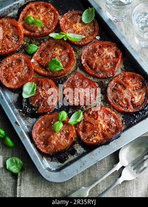 Pomodori al forno con basilico Foto Stock