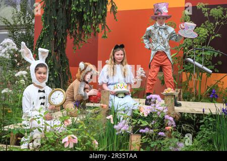 Londra, Regno Unito. 22nd maggio, 2023. Nel Teapot Trust Other Garden, l'ex presentatore intelligente della CBBC, Kirsten o'Brien, si unisce al "Teapot Trust" Tea Party di Mad Hatter, mentre i bambini assumono i ruoli di Alice, Mad Hatter, Dormouse e coniglio Bianco. Giornata stampa all'annuale RHS Chelsea Flower Show, che propone disegni di giardini, prodotti, mostre floreali e tutto ciò che riguarda l'orticoltura dal 23 al 27 maggio. Credit: Imageplotter/Alamy Live News Foto Stock