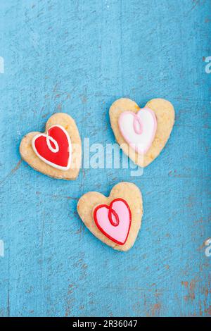 Biscotti a forma di cuore decorati con glassa rossa e bianca Foto Stock