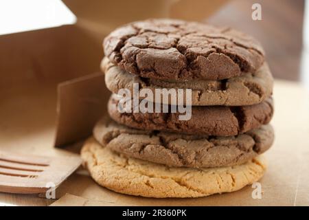 Una pila di biscotti assortiti con scaglie di cioccolato accanto a una scatola Foto Stock