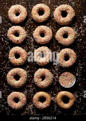 Ciambelle al caramello con coloratissime spruzzate di zucchero Foto Stock