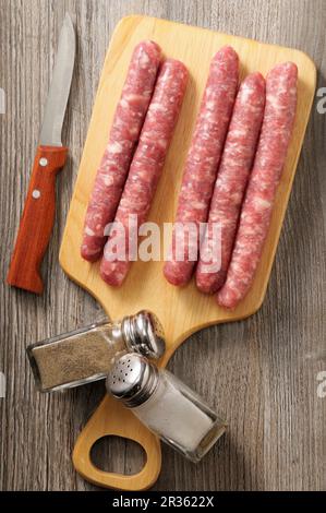 La cipolata sala su un asse di legno con un coltello, pepe e sale Foto Stock