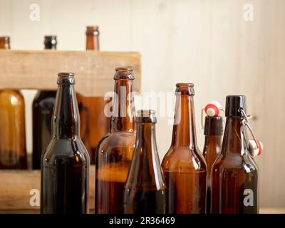 Aprire le bottiglie di birra nella parte anteriore di una gabbia in legno Foto Stock