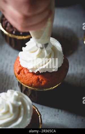 Un cupcake è decorato con panna montata Foto Stock