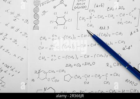 Fogli di carta con diverse formule chimiche e penna, vista dall'alto Foto Stock