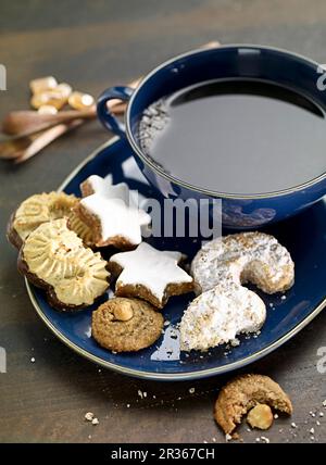 Vari biscotti di Natale su un piatto con una tazza di tè Foto Stock