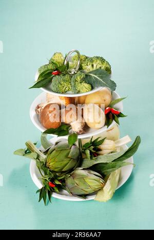 Varie le verdure su una torta di stand Foto Stock