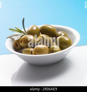 Olive verdi snocciolate in un recipiente bianco Foto Stock