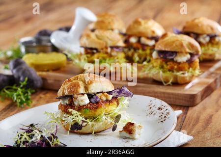Mini hamburger vegetariani con polenta polenta, feta e vari tipi di lattuga Foto Stock