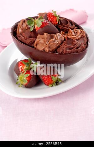 Un uovo di cioccolato ripieno di cioccolato e crema di cioccolato fragole smaltate Foto Stock